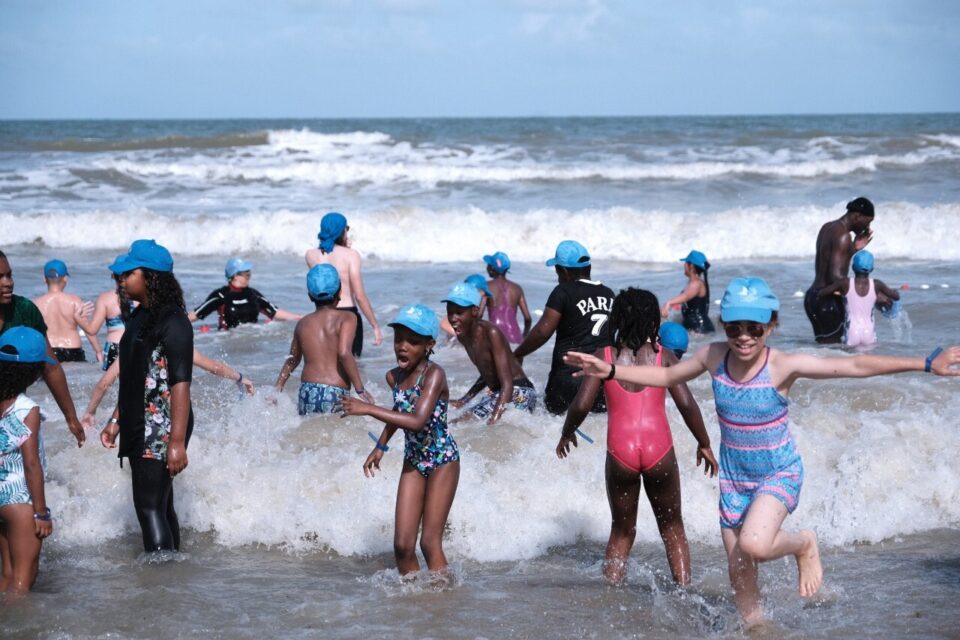 Si l'accueil de ces milliers de gamins pour la Journée des oubliés des vacances est une tradition, chaque été, sur la Côte fleurie, on ne se lassera jamais de leurs sourires éclatants et de leurs cris de joie, en courant sur le sable ou en prenant une vague. Mercredi, sous un soleil perçant, plis de 3 500 d'enfants venus de région parisienne ont investi la plage accompagnés de 1 500 bénévoles Marie de Mante la jolie, bénévole depuis quelques mois pour aider les gens sans rien demander en retour. Doit surveiller quatre enfants. Je n'ai pas mes enfants avec moi mais je suis bien entourée. Dans le bus, ça chantait. Ca me fait du bien. André bénévole à Clichy. Dans le bus, ils posaient plein de questions, on sentait qu'ils étaient déjà pressés d'arriver. Plein de joie à l'arrivée et ça me met en joie. Ils avaient hâte de se baigner. Ils sont émerveillés de voit la mer, les bateaux au loin. Rita, Christine et Annie de Athis-Mons dans l'Essence. Bénévoles depuis longtemps. Il y avait déjà de l'ambiance dans le bus, le voyage c'était deja une aventure pour eux. Cette journée est très importante, ils nous en parlent, ça leur fait des souvenirs. Des fois on connait la situation familiale pas simple de certaines familles, c'est d'autant plus beau de les voir profiter. On sait pourquoi on fait ça. C'est une belle journée.